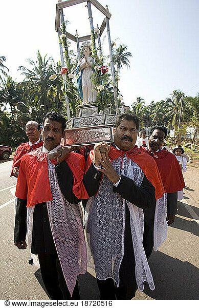 Goan Priest carry Our Lady on silver chariot to St. Alex Church. Goa  India.