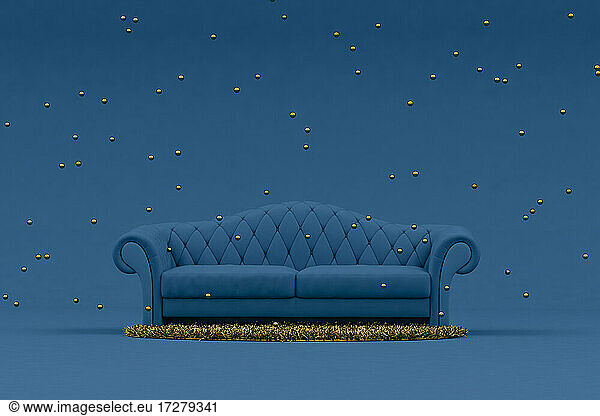 Gold colored spheres hanging over blue sofa