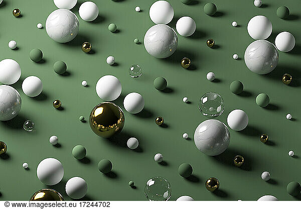 Gold  glass  marble spheres against pastel green background