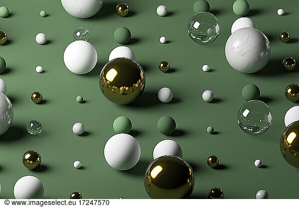 Gold  glass  marble spheres against pastel green background