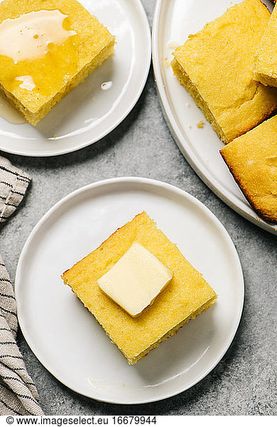 Goldene Maisbrotquadrate mit Butter und Honig