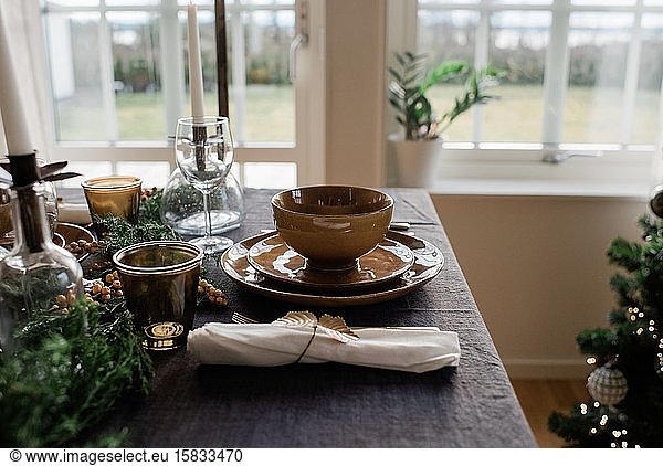 goldene Teller und Besteck auf einem geschmückten Esstisch zu Hause