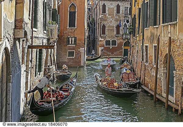 Gondoliere in traditionellen Gondeln  die Touristen auf Sightseeing Touren durch die engen Kanäle in Venedig  Venetien  Nordostitalien  mitnehmen