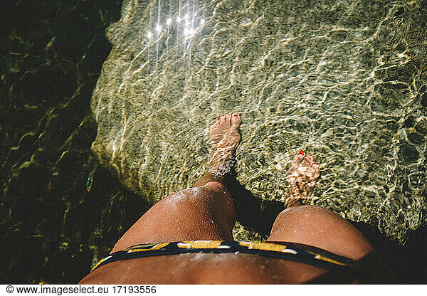 Goosebumps on Tan Legs looking down into clear sunkissed water