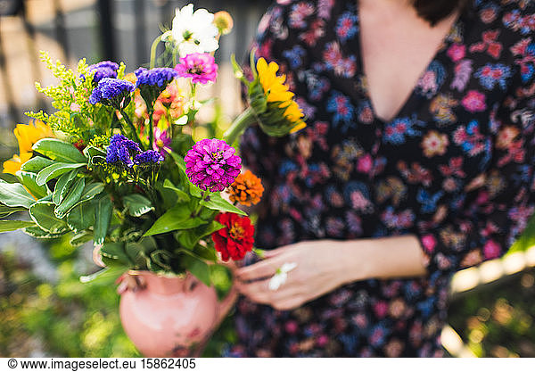 gorgeous summer flowers held by woman in garden
