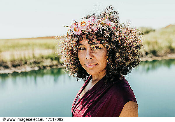 Gorgeous woman with flower crown looks directly into camera