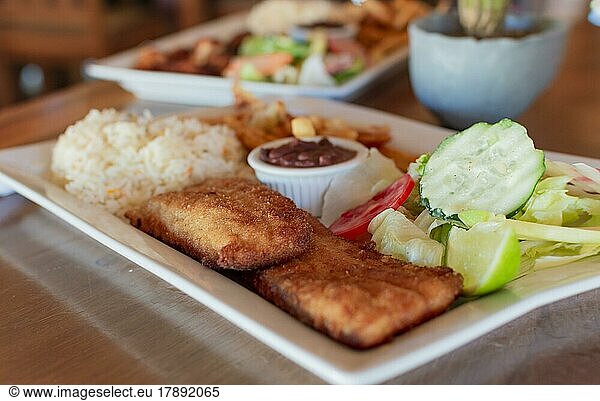 Gourmet-Food gebratenes Fischfilet mit Salat Reis serviert auf Holztisch  Close up von gebratenem Fischfilet mit Reis und Salat auf dem Tisch mit Kopie Raum serviert. Gourmet-Food gebratenes Fischfilet