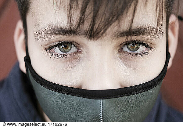 Grünäugiger Junge mit grüner Gesichtsmaske - Schutz vor dem Coronavirus