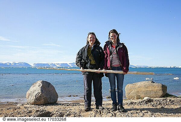 Grönland  Qaanaaq. Frauen mit einem Narwalzahn. Der Narwal (Monodon monoceros) ist ein mittelgroßer Zahnwal  der einen großen Stoßzahn aus einem vorstehenden Eckzahn besitzt.