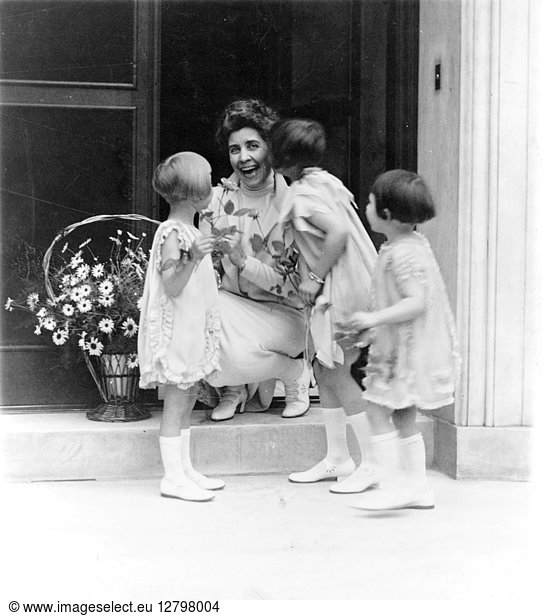 GRACE ANNA COOLIDGE (1879-1957). Wife of President Calvin Coolidge  receiving flowers and a kiss from three children. Photograph  c1927.