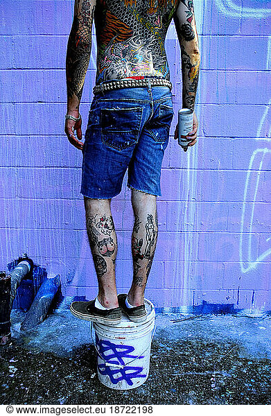 Graffiti artist with tattoos  paints in Austin  Texas.