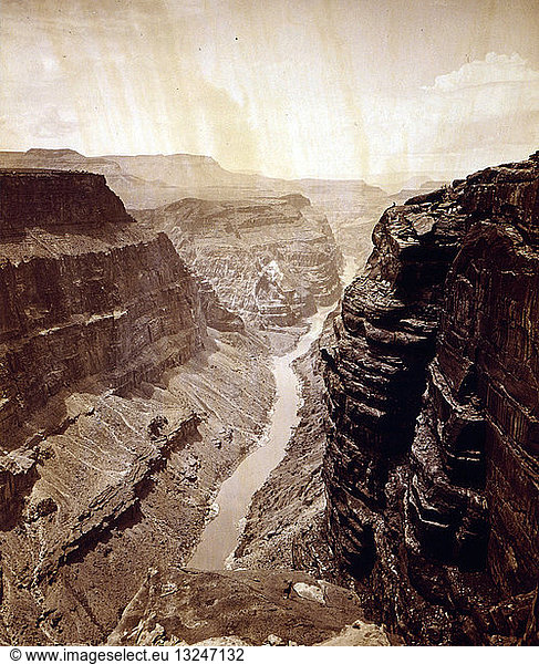 Grand Canyon  Colorado River  looking west by James Fennemore  1849-1941  photographer 1872. View from top of the Grand Canyon. Man sitting on ledge is John Hillers.
