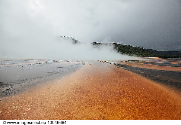 Grand prismatic spring against cloudy sky