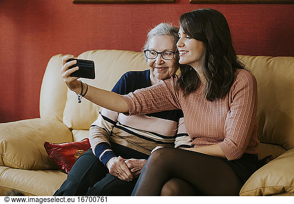 granddaughter and grandmother taking a selfie on the sofa
