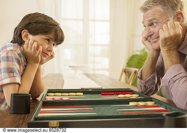 Grandfather and grandson playing backgammon