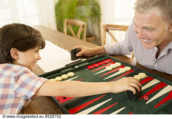 Grandfather and grandson playing backgammon