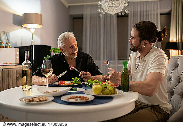 Grandfather and grandson talking during dinner