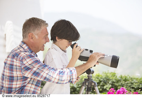 Grandfather and grandson using telescope