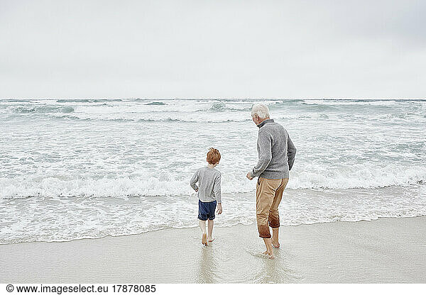 Grandfather playing with grandson at the sea