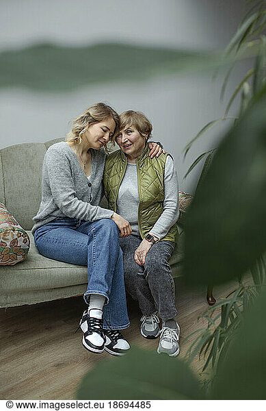Grandmother and granddaughter sitting together in living room
