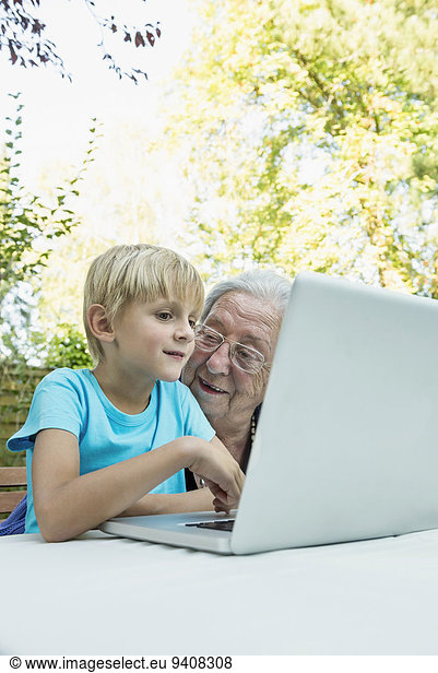 Grandmother and her grandson with laptop