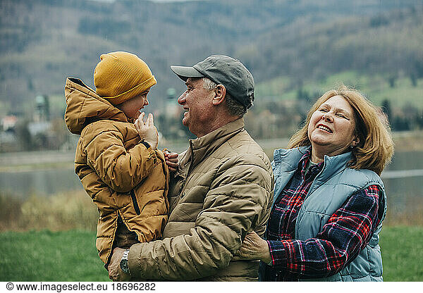 Grandparents having fun with grandson wearing warm clothing