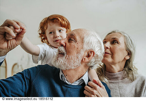 Grandparents playing with grandson at home