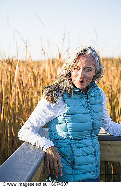 Grauhaarige Frau genießt einen Naturspaziergang im goldenen Sumpf