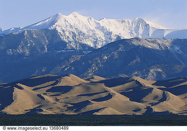 Great Sand Dunes National Park and Preserve  Colorado  in winter. Note the snow blowing off the tops of the San Juan Mountains in the background.