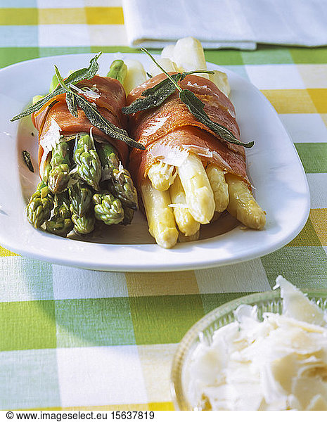 Green and white asparagus wrapped with bacon on plate