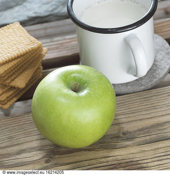 Green apple  biscuits and mug of milk  close-up
