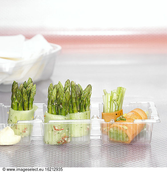 Green asparagus in cucumber and celery in carrots  close-up