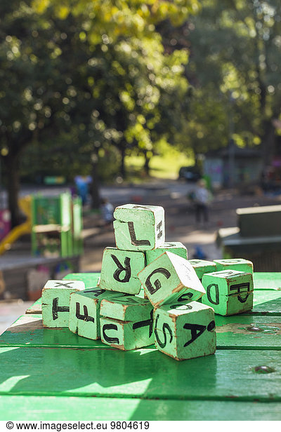 Green wooden blocks on table outside kindergarten