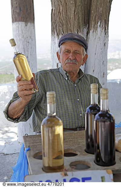 Grieche beim Verkauf von selbstgemachtem Wein  Bergdorf Pirgos  Santorin  Kykladen  Ägäis  Griechenland  Europa