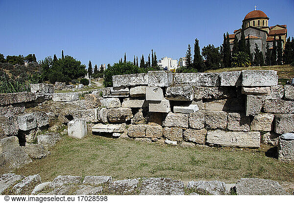 Griechenland,  Athen. Gebiet von Kerameikos (Ceramicus). Sein Name leitet sich von Töpferviertel ab. Nordwestlich der Akropolis. Alter Friedhof. Ruinen. Im Hintergrund die Kirche Agia Triada.