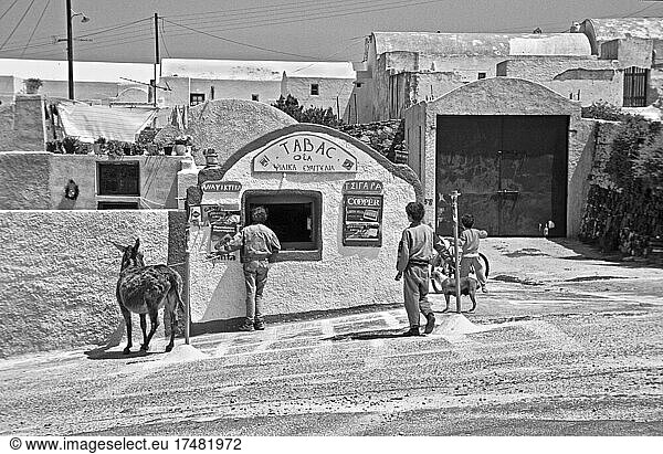 Griechenland 1990  Mann mit Esel vor Kiosk  Kinder vor Kiosk  Reisefotografie  Urlaub  Menschen am Kiosk  Tabakgeschäft  Tourismus  Oia  Santorini  Insel im Mittelmeer  Ägäis   Griechenland  Europa