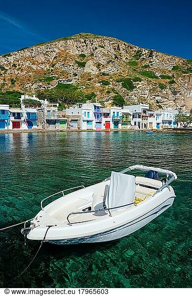 Griechisches Fischerboot in der Ägäis mit malerischem griechischem Dorf Klima im Hintergrund  Insel Milos  Griechenland  Europa
