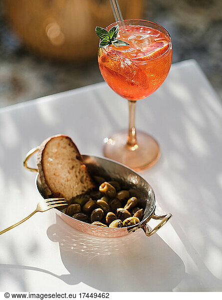 Grilled Mediterranean olives and glass of aperol spritz cocktail
