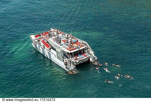 Großes Ausflugsboot  Menschen schwimmen im türkisen Meer  Algarve  Lagos  Portugal  Europa