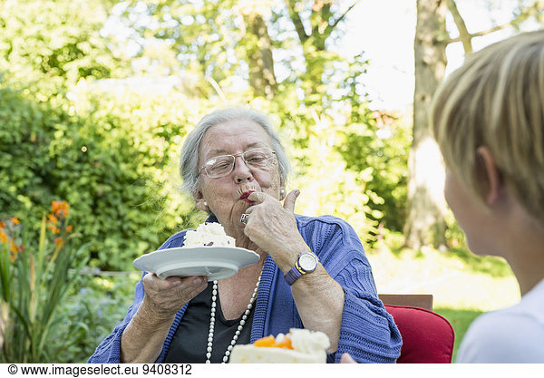 Großmutter Enkelsohn Kuchen essen essend isst Sahne