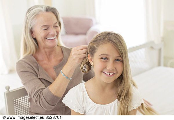 Großmutter flechtet die Haare der Enkelin