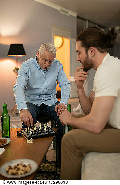Großvater und Enkel denken beim Schachspiel nach