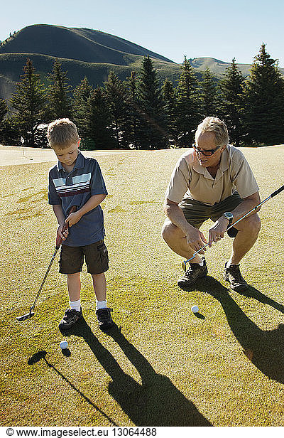 Großvater unterrichtet Golf für Jungen