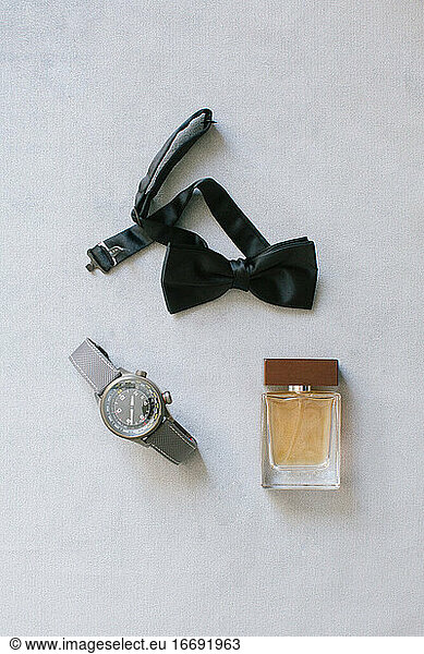 Groom accessories. Wristwatch  bow tie and perfume.