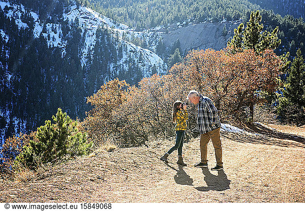 Grossvater und Enkelin beim Wandern in den Bergen beim Fotografieren
