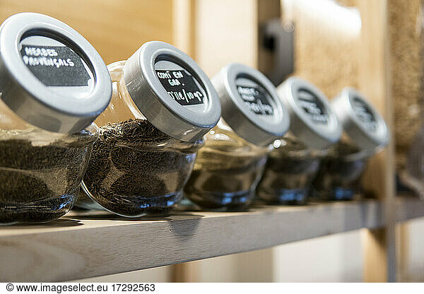Ground coffee in containers arranged at retail display in supermarket