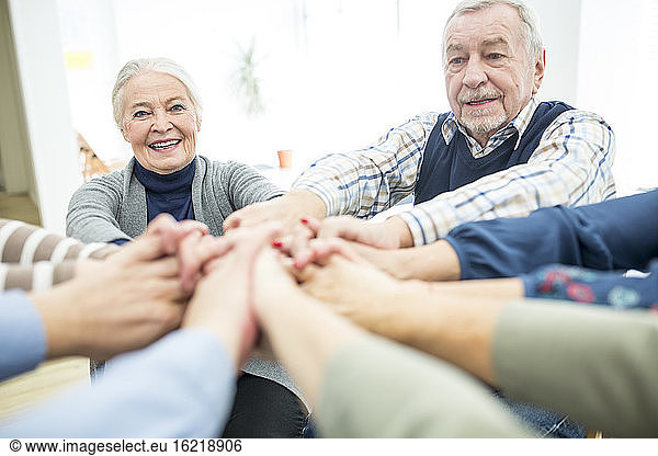 Group of active seniors stacking hands  symbolizing solidarity