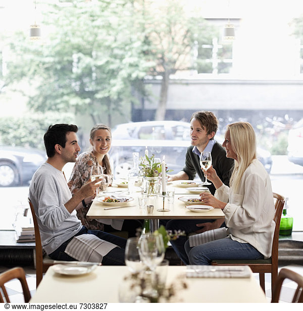 Group of friends communicating at restaurant table