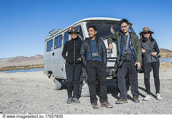 group of friends posing in front of their rugged 4x4 van