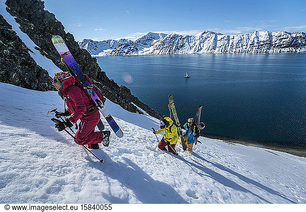 Group of friends skinning up mountain to ski in Svalbard